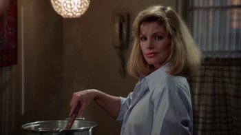 Movie still from “The Naked Gun: From the Files of Police Squad!” (1988), directed by David Zucker – A woman in a white shirt is stirring a pot; Close Up shot, Low angle