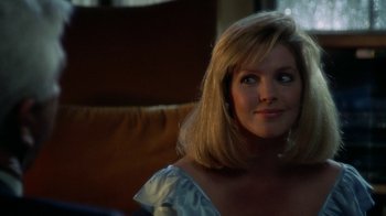 Movie still from “The Naked Gun: From the Files of Police Squad!” (1988), directed by David Zucker – A woman with blonde hair sitting on a couch; Close Up shot, Over the shoulder angle