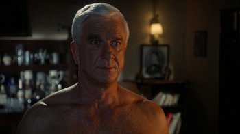 Movie still from “The Naked Gun: From the Files of Police Squad!” (1988), directed by David Zucker – An older man with white hair is looking at the camera; Close Up shot, Over the shoulder angle