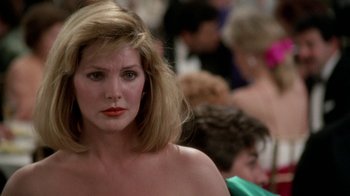 Movie still from “The Naked Gun: From the Files of Police Squad!” (1988), directed by David Zucker – A person wearing a dress; Close Up shot, Over the shoulder angle