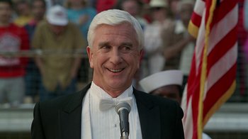Movie still from “The Naked Gun: From the Files of Police Squad!” (1988), directed by David Zucker – An older man wearing a white bow tie and a black suit; Close Up shot, Low angle