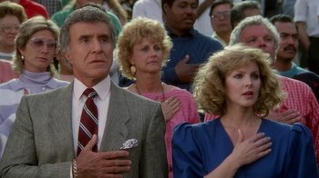 Movie still from “The Naked Gun: From the Files of Police Squad!” (1988), directed by David Zucker – A group of people standing next to each other in a crowd; Medium shot, Low angle