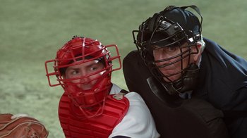 Movie still from “The Naked Gun: From the Files of Police Squad!” (1988), directed by David Zucker – Two baseball players wearing catchers gear posing for a picture; Close Up shot, Over the shoulder angle