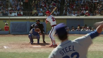 Movie still from “The Naked Gun: From the Files of Police Squad!” (1988), directed by David Zucker – A baseball player holding a bat on top of a baseball field; Wide shot, Over the shoulder angle