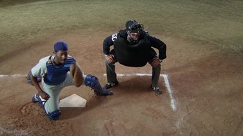 Movie still from “The Naked Gun: From the Files of Police Squad!” (1988), directed by David Zucker – A baseball player standing next to a catcher on a baseball field; Wide shot, Overhead angle
