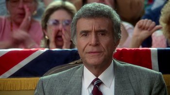 Movie still from “The Naked Gun: From the Files of Police Squad!” (1988), directed by David Zucker – An older man wearing a gray suit and a red neck tie; Close Up shot, High angle