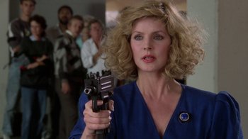 Movie still from “The Naked Gun: From the Files of Police Squad!” (1988), directed by David Zucker – A person holding a gun; Close Up shot, Low angle