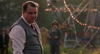 Movie still from “The Natural” (1984), directed by Barry Levinson – A man in a suit and tie standing next to another man in a suit and tie; Medium shot, Low angle