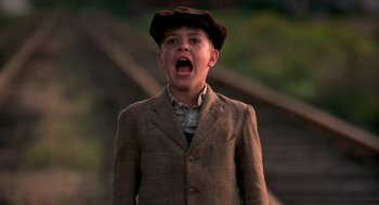 Movie still from “The Natural” (1984), directed by Barry Levinson – A young boy wearing a hat and a jacket; Medium shot, Low angle