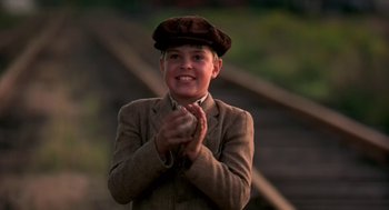Movie still from “The Natural” (1984), directed by Barry Levinson – A boy in a brown suit clapping his hands; Medium shot, Low angle