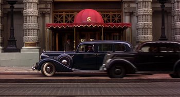 Movie still from “The Natural” (1984), directed by Barry Levinson – An old car parked on the side of the street; Wide shot, Low angle
