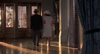 Movie still from “The Natural” (1984), directed by Barry Levinson – A man and a woman walking down a hall way; Wide shot, Low angle
