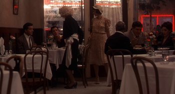Movie still from “The Natural” (1984), directed by Barry Levinson – A group of people sitting at a table in a restaurant; Wide shot, Over the shoulder angle