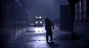 Movie still from “The Natural” (1984), directed by Barry Levinson – A man walking down a street in the dark; Wide shot, Over the shoulder angle