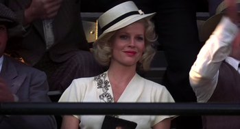 Movie still from “The Natural” (1984), directed by Barry Levinson – A woman with blonde hair wearing a white hat; Close Up shot, Low angle