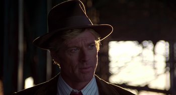 Movie still from “The Natural” (1984), directed by Barry Levinson – A person wearing a suit and hat; Close Up shot, Over the shoulder angle