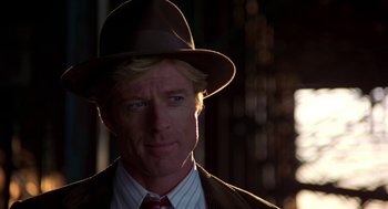 Movie still from “The Natural” (1984), directed by Barry Levinson – A person wearing a hat and a suit; Close Up shot, Over the shoulder angle