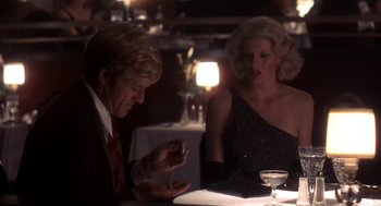 Movie still from “The Natural” (1984), directed by Barry Levinson – A man and a woman sitting at a dinner table; Medium shot, Over the shoulder angle