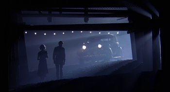 Movie still from “The Natural” (1984), directed by Barry Levinson – Two people are standing in front of an old car; Wide shot, Low angle