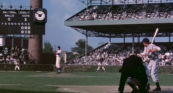 Movie still from “The Natural” (1984), directed by Barry Levinson – A baseball player holding a bat on top of a baseball field; Extreme Wide shot, High angle