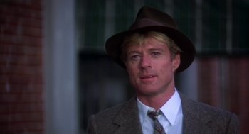 Movie still from “The Natural” (1984), directed by Barry Levinson – A person wearing a suit and a hat; Close Up shot, Over the shoulder angle