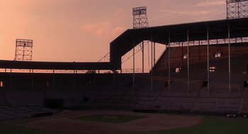 Movie still from “The Natural” (1984), directed by Barry Levinson – A baseball field with a bleachers and a stand in the middle of the field; Extreme Wide shot, High angle