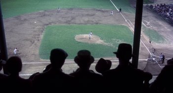 Movie still from “The Natural” (1984), directed by Barry Levinson – A group of men standing on top of a baseball field; Extreme Wide shot, Overhead angle