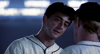 Movie still from “The Natural” (1984), directed by Barry Levinson – A baseball player wearing a white and black uniform; Close Up shot, Over the shoulder angle