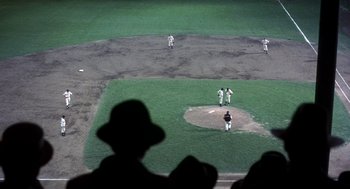Movie still from “The Natural” (1984), directed by Barry Levinson – A group of baseball players standing on top of a baseball field; Extreme Wide shot, High angle