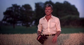 Movie still from “The Natural” (1984), directed by Barry Levinson – A man standing in the middle of a field holding a baseball glove; Medium shot, Low angle