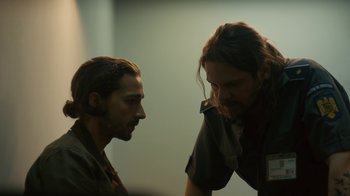 Movie still from “Charlie Countryman” (2013), directed by Fredrik Bond – A man and a woman talking to each other in front of a wall; Medium shot, Over the shoulder angle
