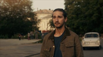 Movie still from “Charlie Countryman” (2013), directed by Fredrik Bond – Shia labeouf is standing in front of a building; Close Up shot, Over the shoulder angle