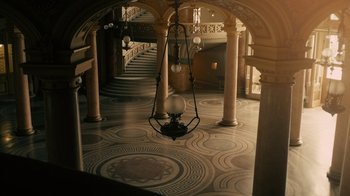 Movie still from “Charlie Countryman” (2013), directed by Fredrik Bond – An ornate hall way with a chandelier hanging from the ceiling; Extreme Wide shot, High angle