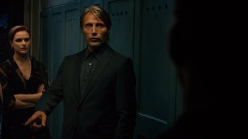 Movie still from “Charlie Countryman” (2013), directed by Fredrik Bond – A man in a suit standing in front of a row of lockers; Medium shot, Low angle
