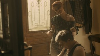 Movie still from “Charlie Countryman” (2013), directed by Fredrik Bond – A woman standing next to a man in front of a window; Medium shot, Over the shoulder angle