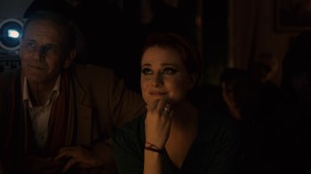 Movie still from “Charlie Countryman” (2013), directed by Fredrik Bond – A woman sitting in the dark with her hand on her chin; Close Up shot, Over the shoulder angle