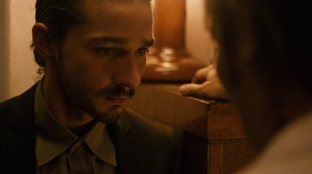 Movie still from “Charlie Countryman” (2013), directed by Fredrik Bond – A person sitting on a chair; Close Up shot, Over the shoulder angle