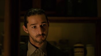 Movie still from “Charlie Countryman” (2013), directed by Fredrik Bond – A person wearing a suit and tie; Close Up shot, Over the shoulder angle