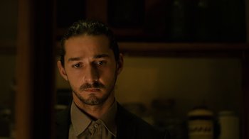 Movie still from “Charlie Countryman” (2013), directed by Fredrik Bond – A person wearing a suit and tie; Close Up shot, Over the shoulder angle