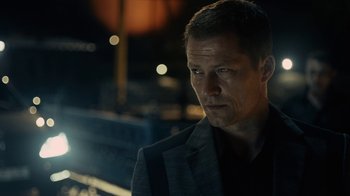 Movie still from “Charlie Countryman” (2013), directed by Fredrik Bond – A person wearing a suit and tie; Close Up shot, Over the shoulder angle