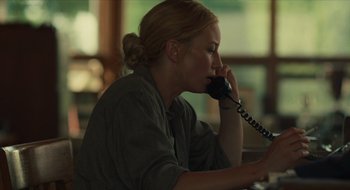 Movie still from “The Nest” (2020), directed by Sean Durkin – A woman sitting at a table talking on a phone; Close Up shot, Over the shoulder angle