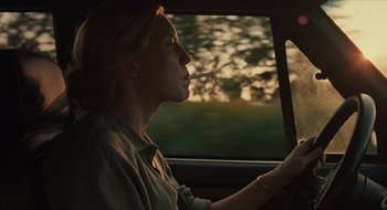 Movie still from “The Nest” (2020), directed by Sean Durkin – A woman sitting in the driver's seat of a car while smoking a cigarette; Medium shot, Over the shoulder angle