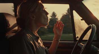 Movie still from “The Nest” (2020), directed by Sean Durkin – A woman sitting in the driver's seat of a car; Medium shot, Low angle