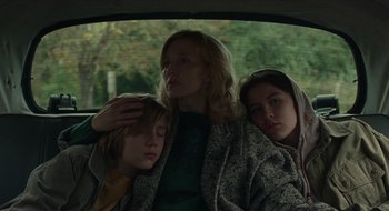 Movie still from “The Nest” (2020), directed by Sean Durkin – A woman and two children in the back seat of a car; Medium shot, Low angle