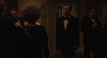 Movie still from “The Nest” (2020), directed by Sean Durkin – A man in a tuxedo standing next to a woman in a black dress; Medium shot, Over the shoulder angle