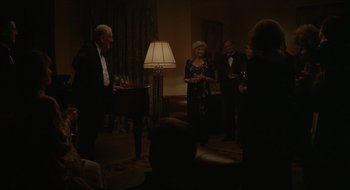 Movie still from “The Nest” (2020), directed by Sean Durkin – A group of people standing around a living room; Wide shot, Over the shoulder angle