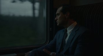 Movie still from “The Nest” (2020), directed by Sean Durkin – A man in a suit sitting in front of a window; Medium shot, Over the shoulder angle