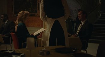 Movie still from “The Nest” (2020), directed by Sean Durkin – A man in a white shirt is holding a menu; Medium shot, Over the shoulder angle