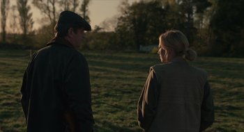 Movie still from “The Nest” (2020), directed by Sean Durkin – A man and a woman are standing in a field; Medium shot, Over the shoulder angle