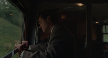 Movie still from “The Nest” (2020), directed by Sean Durkin – A man in a suit looking at his cell phone; Medium shot, Low angle